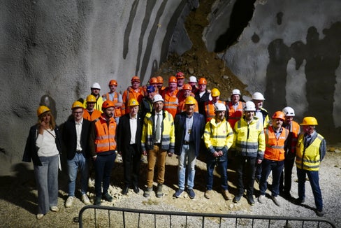 La foto simbolica appena avvenuto l'abbattimento dell'ultimo diaframma del tunnel. L'assessore provinciale Alfreider (quinto da sinistra in prima fila) ha sottolineato: “Con questo abbattimento facciamo un passo concreto verso un obiettivo molto chiaro: alleggerire il centro di Chienes, aumentare la sicurezza lungo l’asse della Pusteria e migliorare la qualità della vita delle persone che vivono qui”. (Foto: USP/Ingo Dejaco)