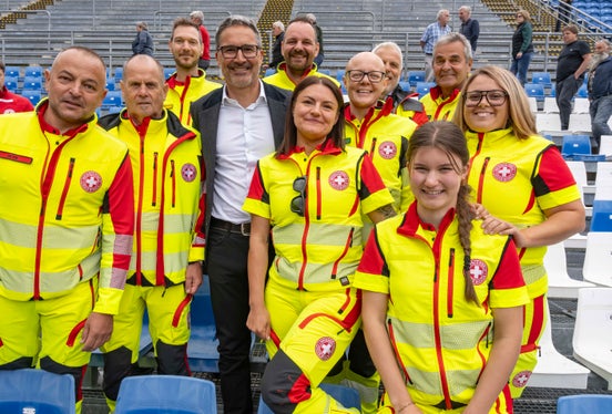 Il presidente della Provincia Arno Kompatscher posa con una delegazione della Croce Bianca, parte attiva assai preziosa durante la recente edizione dei Giochi Olimpici Invernali ad Anterselva. (Foto: USP/Othmar Seehauser)