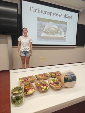 Una studentessa del 4° anno del corso di Tecnologie Alimentari della Scuola professionale Laimburg durante la presentazione del formaggio ai germogli di abete rosso da lei ideato. (Foto: USP/Scuola professionale Laimburg)