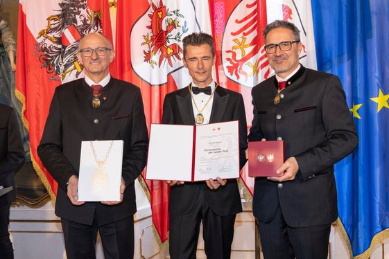 Il presidente del Land Tirolo Anton Mattle (a sinistra) e il presidente della Provincia autonoma di Bolzano Arno Kompatscher (a destra) consegnano l'onorificenza al musicista altoatesino Herbert Pixner (Foto: Land Tirol/Die Fotografen)