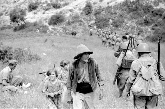 Bild aus dem fotografischen Nachlass von Wilhelm Schrefler, seit 1935 Guglielmo Sandri: Eine italienische Marschkolonne trifft auf einen Bauern und zwei Kinder. (LPA/Landesarchiv)