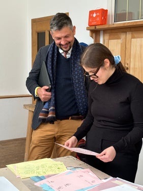 Lehrerin Celine Silbernagl zeigte Landesrat Daniel Alfreider kreative Comics, die während eines Workshops in der Scola de Creativitá in St. Ulrich entstanden sind (Foto: LPA/Ladinische Bildung und Kultur/Sara Runggaldier)