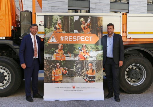 An 80 Stellen entlang der Straßen weisen die Plakate, die LR Alfreider und Abteilungsdirektor Sicher vorgestellt haben, auf die Arbeit der Straßenwärter hin. (Foto: LPA/Ingo Dejaco)
