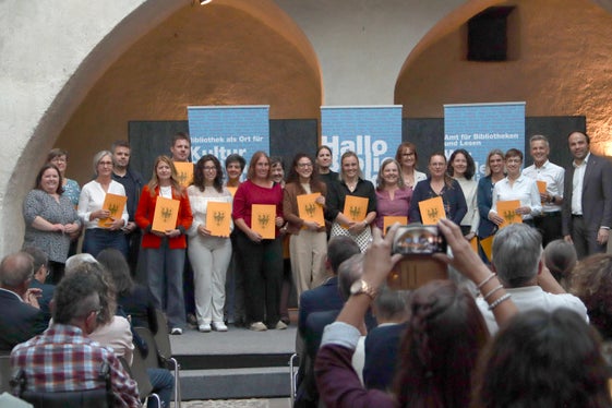 Bei der Grundausbildung geht es um die Vermittlung von Literatur, ebenso um Leseförderung, Öffentlichkeits- und Veranstaltungsarbeit und Zusammenarbeit mit Partnern. Im Bild ein Teil der Absolventinnen und Absolventen 2026 mit Amtsdirektorin Gamper (rechts) und Landesrat Achammer (links). (Foto: Amt für Bibliotheken und Lesen)