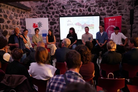 Univ. Prof. Ulrike Kindl (stehend l.) ging auf die vielen Facetten des Heimatbegriffes ein. (Foto: Euregio/Armin Gluderer)
