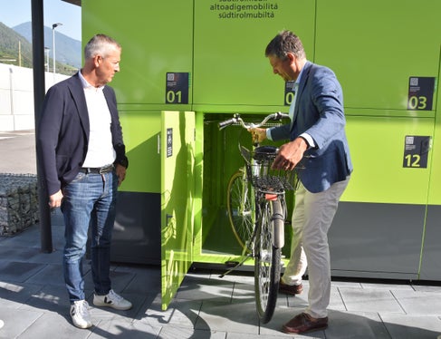 Bürgermeister Peter Brunner (l.) und Mobilitätslandesrat Daniel Alfreider testen die Einzelboxen für Fahrräder im Mobilitätszentrum Brixen. (Foto: LPA/Angelika Schrott)