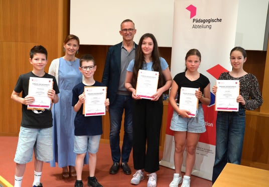 Prämierungsfeier Känguru der Mathematik 2026: 1. Klasse Mittelschule – Kategorie Benjamin (von links): Janick Schwienbacher, Paul Dorigoni, Eleonora Petritsch, Stina Malfertheiner, Laura Preindl, dahinter Landesschuldirektorin Sigrun Falkensteiner und Abteilungsdirektor Martin Holzner (Foto: LPA/Deutsche Bildungsdirektion/Margit Pichler)