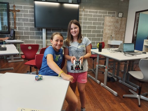Unseren Lego-Roboter haben wir so programmiert, dass er viele verschiedene Aufgaben erfüllen kann, berichten Pauline (links) und Lea. (Foto: LPA/Begabungs- und Begabtenförderung der Pädagogischen Abteilung der Deutschen Bildungsdirektion/Franziska Volgger)