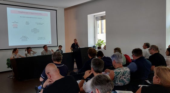 La direttrice dell’Ufficio Judith Notdurfter (in primo piano sul podio) e i suoi collaboratori si sono messi a disposizione dei rappresentanti e delle rappresentanti delle associazioni presenti anche per rispondere alle loro domande. (Foto: USP/Ufficio Volontariato e solidarietà)