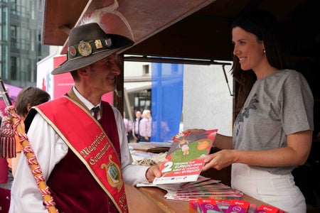 Ein Musikant informiert sich am Euregio-Stand bei Mitarbeiterin Costanza Pozzo. (Foto: Euregio)