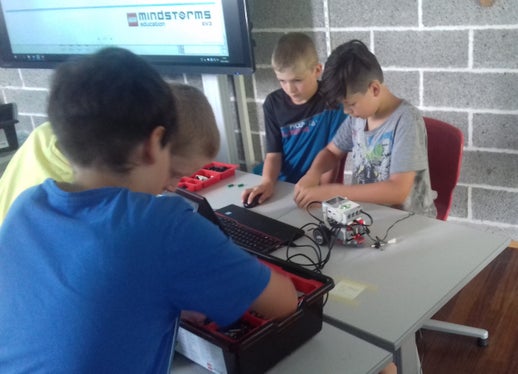 Matthias Hellweger, Gabriel Schönweger, Markus Taschler und Philip Costabiei (v.l.n.r) beim Lego-Roboter bauen und programmieren. (Foto: LPA/Martin Niederkofler)