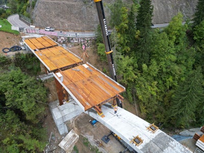 Die Montage der Bauteile der neuen Brücke beim Schloss Eschenlohe auf der Landesstraße im Ultental erfolgt mit einem Autokran. (Foto: LPA/DNA)