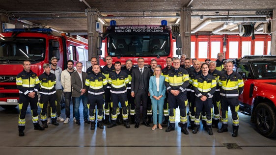 Insieme per un Corpo permanente dei vigili del fuoco forte: i rappresentanti del Corpo permanente dei vigili del fuoco con l’assessora provinciale al Personale Magdalena Amhof (in primo piano al centro), il presidente della Provincia Arno Kompatscher (a sinistra di Amhof) e il comandante del Corpo permanente dei vigili del fuoco di Bolzano, Florian Alber (a destra di Amhof), in occasione della presentazione del nuovo contratto nel deposito veicoli del Corpo permanente dei vigili del fuoco di Bolzano. (Foto: USP/Fabio Brucculeri)