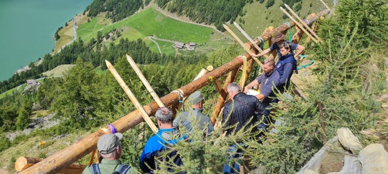 Mitarbeiter des Landesamtes für Wildbach- und Lawinenverbauung West führen Mitarbeiter des Forstinspektorates Meran zur Lawinenverbauung Hochegg in Vernagt; im Bild die Holzrechen, deren Gesamtlänge 152 Meter umfasst. (Foto: LPA/Forstinspektorat Meran)