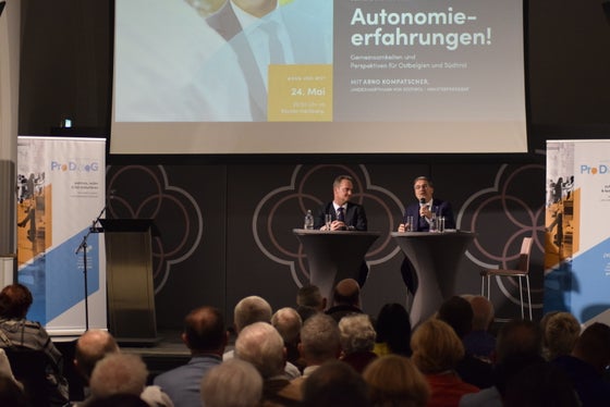 Il primo ministro Paasch (a sinistra sul podio) e il presidente Kompatscher gestiscono modelli simili di Autonomia, anche se in un quadro costituzionale diverso. (Foto: BRF)