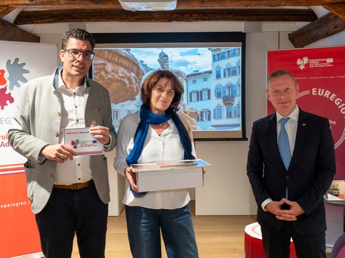 Lorenza Panizza, trentina di Roverè della Luna, posa davanti alla sua splendida foto della fontana del Nettuno di piazza Duomo, a Trento, tra Matthias Fink (a sinistra) e Christoph von Ach (a destra). (Foto: ASP/Fabio Brucculeri)
