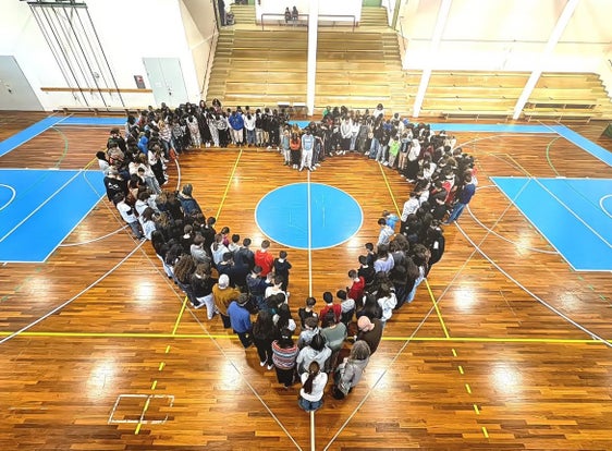 Insieme per una scuola forte e unita. Le ragazze e i ragazzi delle Fermi riuniti "a cuore" all'interno della palestra. (Foto: USP)