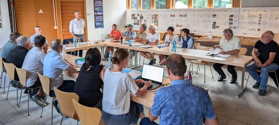 Durante la riunione del Comitato di gestione, l'assessore provinciale Peter Brunner (in piedi) ha sottolineato la sua importanza nella progettazione e nell'attuazione delle misure di protezione e manutenzione del Parco nazionale dello Stelvio, che devono essere attuate in base alle esigenze della popolazione. (Foto: ASP/Vera Brunetti)
