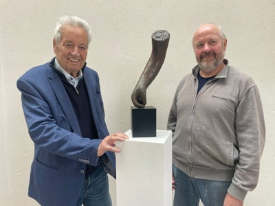 Stifter Wendelin Weingartner (links) und der Künstler Lois Anvidalfarei zeigen die Plastik des Euregio-Baukulturpreises. (Foto: Euregio)