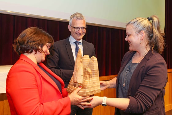 Ein besonderer Preis: Die Skulptur wurde vom Tiroler Künstler Helmut Mayr aus verschiedenen im Bergwald vorkommenden Holzarten gefertigt. Ulrike Huber (links) und Günther Unterthiner (Mitte) nahmen den Preis aus den Händen von Caroline Heiri (rechts) entgegen. (Foto: Brigitt Risch)