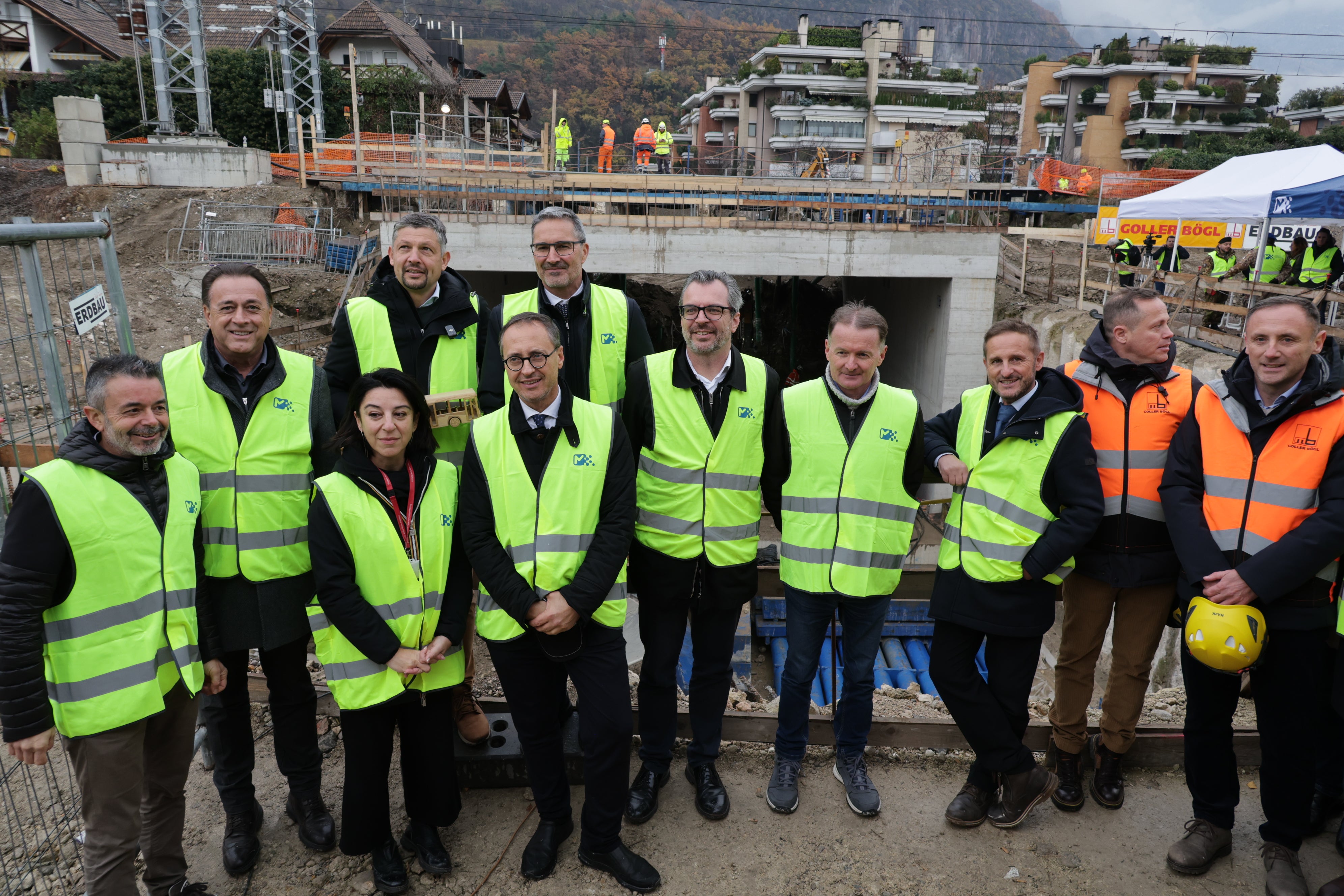 Sie besichtigten die Baustelle (von links): STA-Geschäftsführer Joachim Dejaco, der Präsident der Bezirksgemeinschaft Überetsch-Unterland Hansjörg Zelger, die Investitionsleiterin RFI-Bahnhöfe Nord Susanna Borelli, dahinter Landesrat Daniel Alfreider und Landeshauptmann Arno Kompatscher, Roger Hopfinger (Ferrovie dello Stato), der Bürgermeister von Leifers Giovanni Seppi, Ivan Moroder, der Direktor des Mobilitätsamtes der Gemeinde Bozen, Manfred Mussner, der Leiter der staatlichen zivilen Luftfahrtbehörde ENAC am Bozner Flughafen und Vertretern der Baufirmen. (Foto: LPA/Ingo Dejaco)