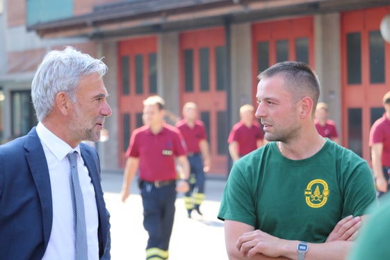 Wünsche das richtige Maß an Mut und Besonnenheit, um von den Einsätzen und Übungen immer wieder gesund zurückzukommen: Bevölkerungsschutzlandesrat Schuler mit einem der neuen Berufsfeuerwehrmänner (Foto: LPA/Maja Clara)