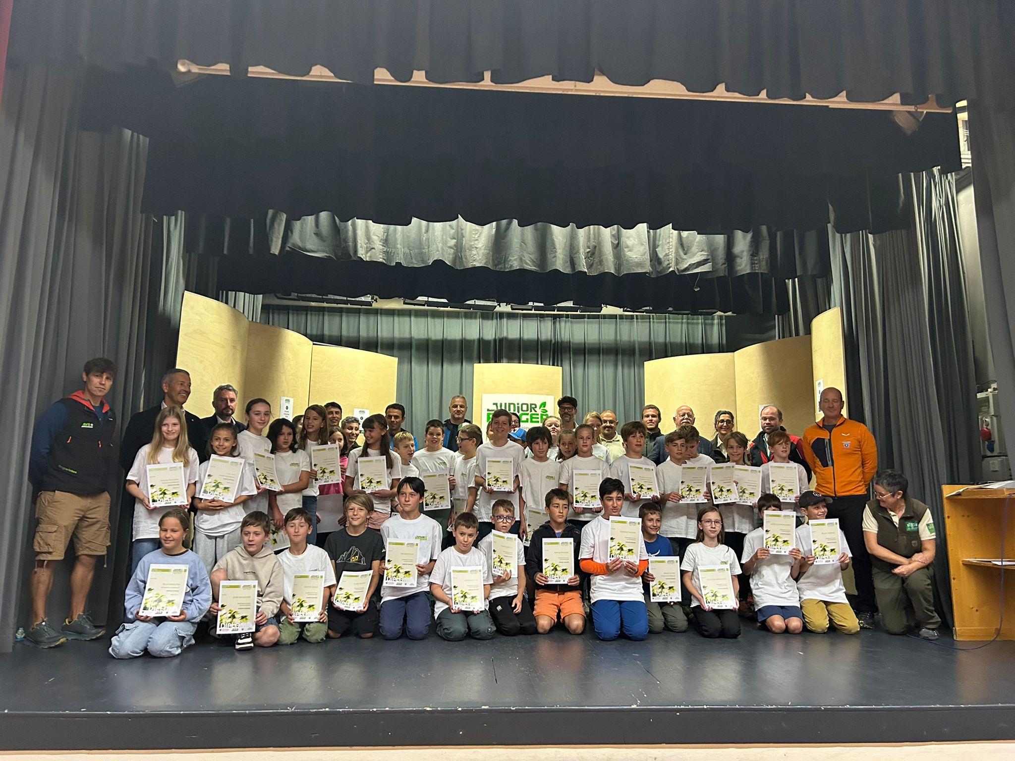 45 naturbegeisterte Kinder zwischen 10 und 11 Jahren haben am 2. August bei einer Feierstunde im Vereinssaal von Wengen ihre Naturpark Junior Ranger 2025-Diplome bekommen. Anwesend waren zahlreiche Ehrengäste wie Landesrat Peter Brunner (stehend, 2.v.l.) (Foto: LPA/Ralf Pechlaner)