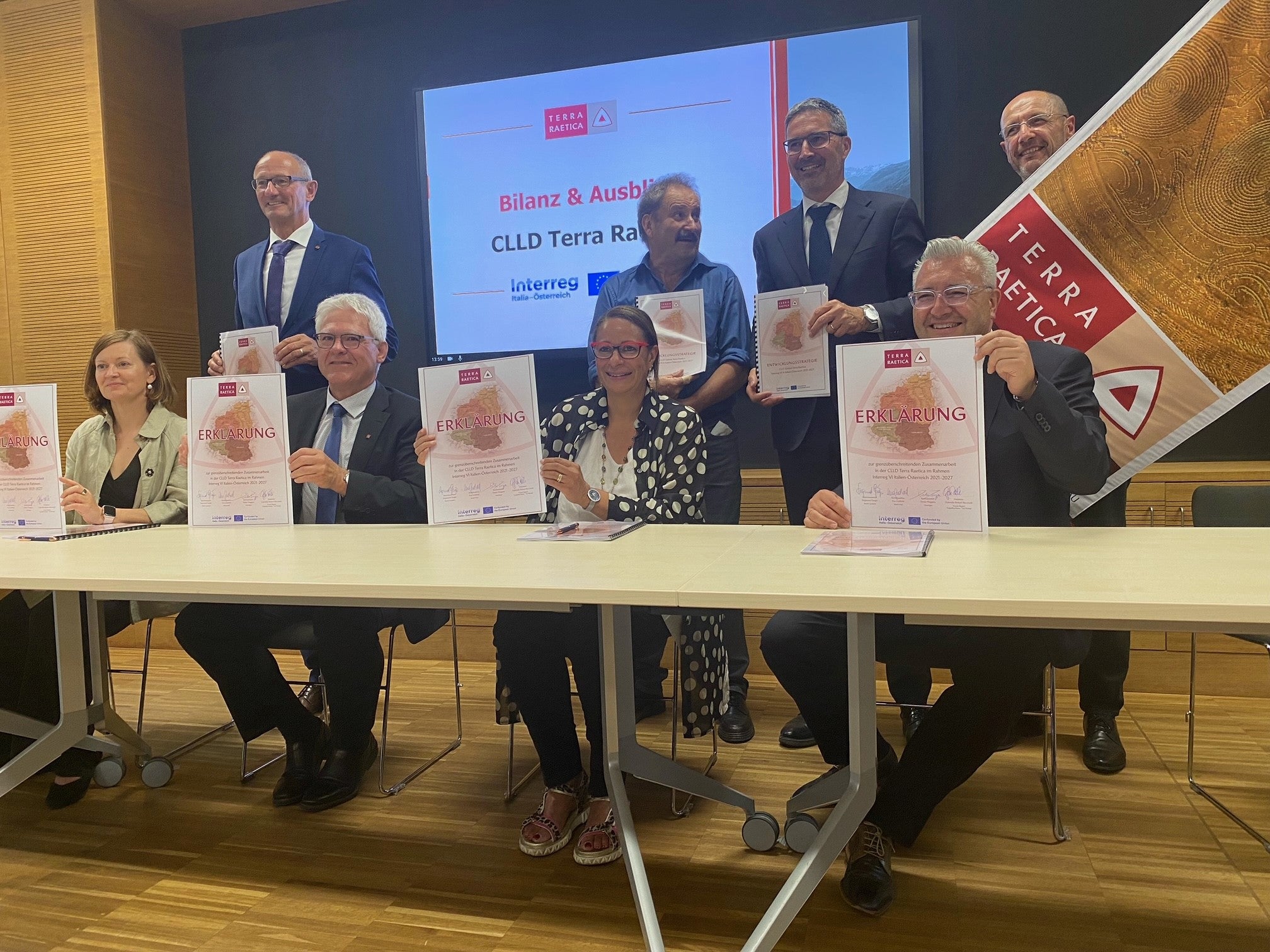 Plasmare il futuro insieme, a livello transfrontaliero e locale: questo è l'obiettivo della Strategia Interreg CLLD Terra Raetica. I rappresentanti delle due città di Imst e Nauders, della Bassa Engadina/Val Monastero e della Val Venosta hanno firmato l'accordo, assieme a loro in piedi da sinistra il presidente del Tirolo Anton Mattle, il presidente della Bassa Engadina/Val Monastero Victor Peer e il presidente Arno Kompatscher hanno fatto da padrini insieme al presidente del Consiglio Interreg Andreas Tappeiner (all'estrema destra, in piedi). (Foto: ASP/Martha Gärber).