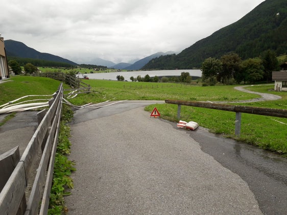Die Freiwillige Feuerwehr in St. Valentin/Graun pumpt seit den Nachtstunden Keller in verschiedenen Gebäuden in St. Valentin/Graun aus; im Hintergrund der Haidersee. (Foto: Franz Alfred Prieth)