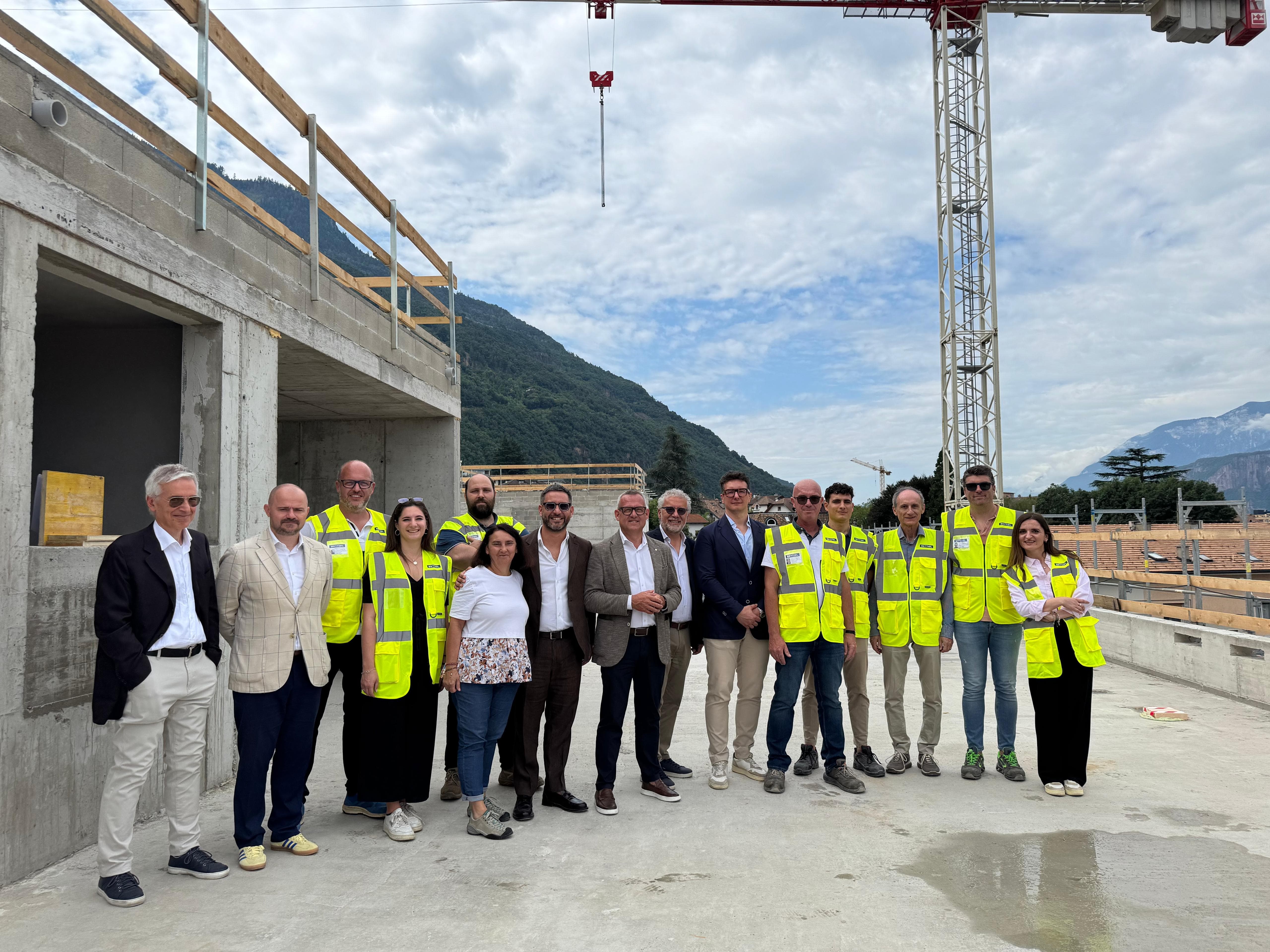 Für das neue Gemeinschaftshaus in Leifers steht der Rohbau. Bei einer kleinen Firstfeier haben Vertreter von Land und Gemeinde das Gebäude begutachtet.  (Foto: LPA/Gianluca Crocco)
