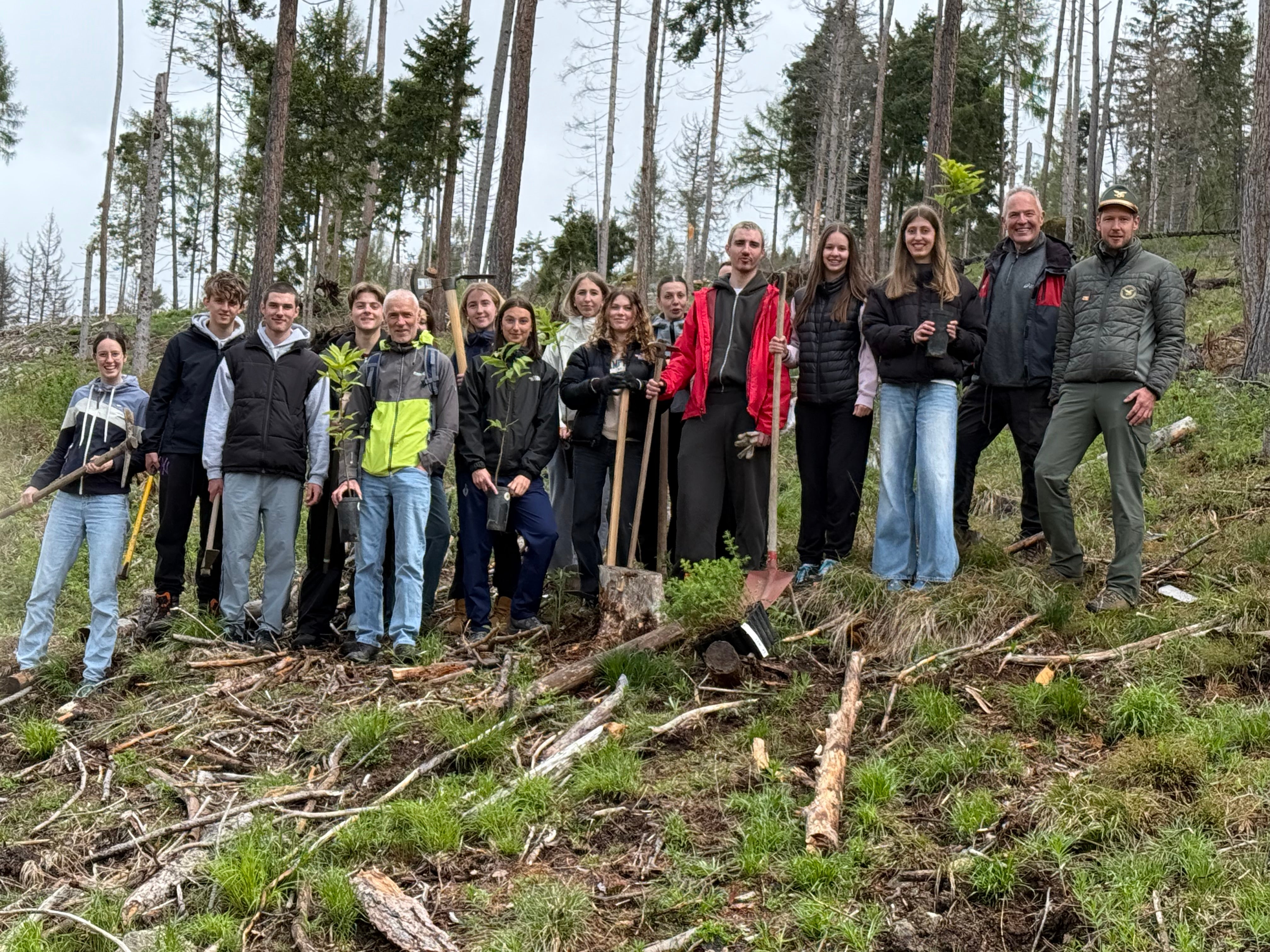 Bäume für die Zukunft: Schülerinnen und Schüler einer der beiden am Projekt beteiligten Maturaklassen des Sprachen- und Realgymnasiums Bruneck bei der Baumpflanzaktion mit dem Leiter der Forststation Bruneck Stefan Schwingshackl (ganz rechts) und Grundeigentümer Peter Rech (Zweiter von rechts) am 8. Mai. (Foto: LPA/Forststation Bruneck)