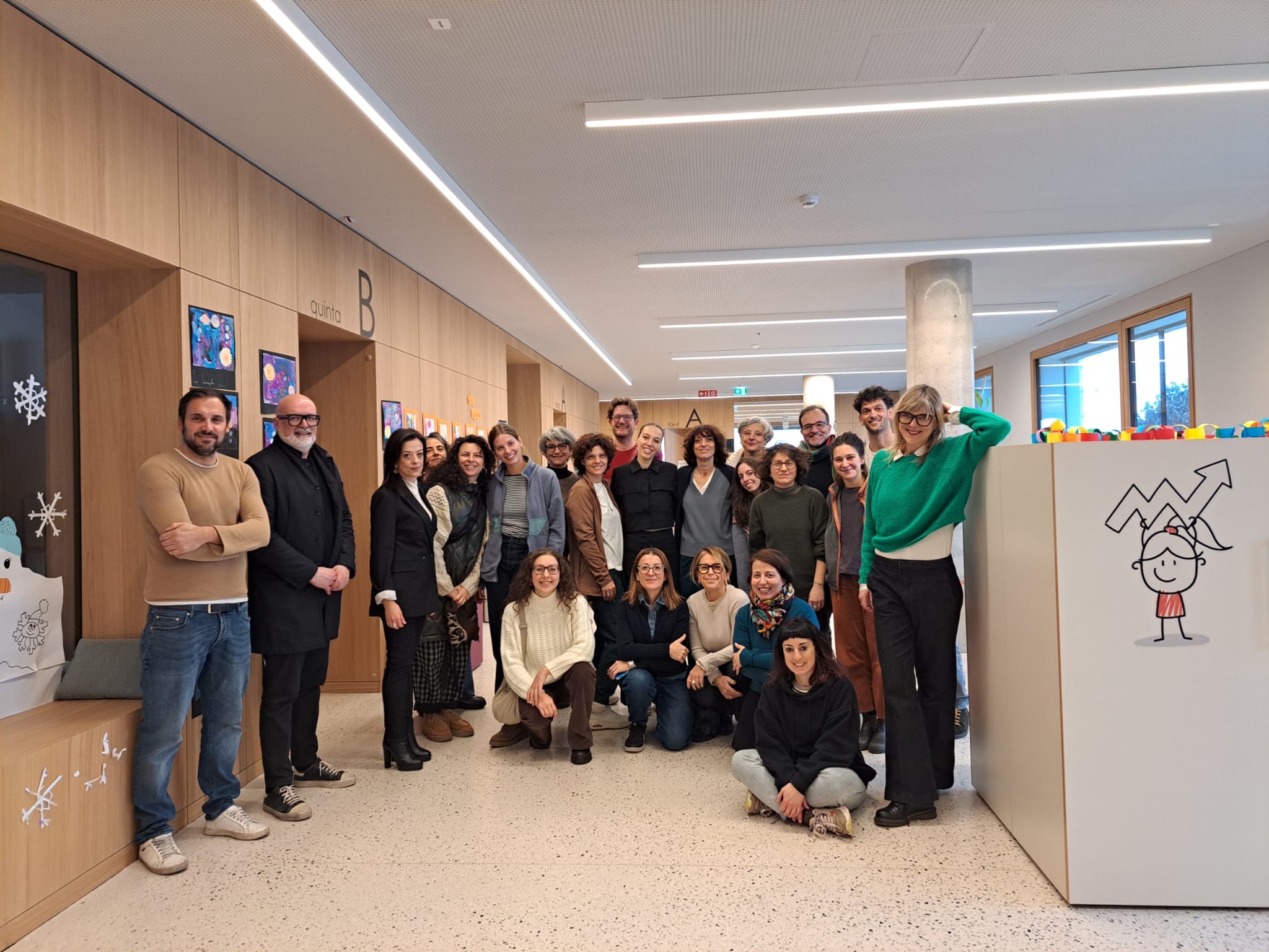 Gruppenfoto der Teilnehmenden des Masterlehrgangs Edenspaces der Freien Universität Bozen beim Besuch der Grundschule St. Jakob mit den Schuldirektorinnen Emanuela Scicchitano und Veronika Fink sowie den Architekten Roberto Pauro und Patrick De Mattio. (Foto: LPA)
