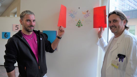 Alex Staffler e Davide Gianotti, Primario e Coordinatore tecnico-assistenziale del Reparto di neonatologia e terapia intensiva neonatale alle prese con il calendario d'Avvento donato dai bambini della scuola primaria Galilei di Merano. (Foto: ASP/Direzione istruzione e formazione italiana)