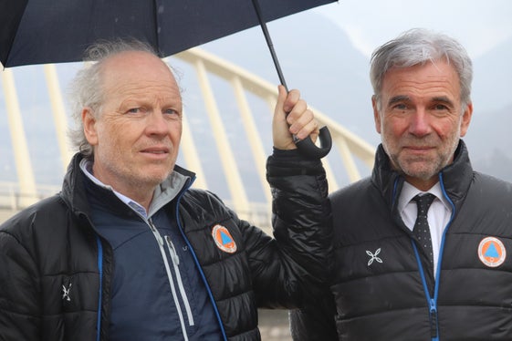 Lokalaugenschein: Landesrat Schuler (re.) und Wildbach-Direktor De Polo heute während des kurzen Regenschauers beim Abbruch der alten Brücke über die Etsch in Neumarkt. (Foto: LPA/Maja Clara)