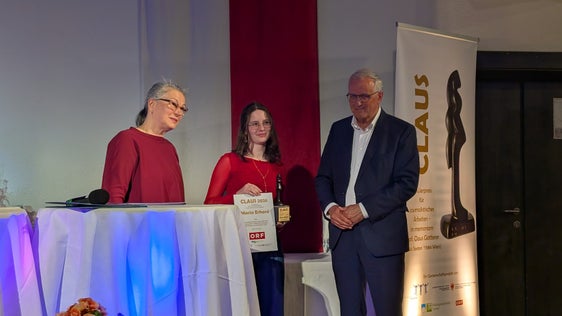 Maria Erhard (Mitte) ging mit ihrem Videobeitrag zur ladinischen Sprache als Siegerin des Schülerpreises CLAUS hervor, im Bild mit Jurymitglied Teresa Indjein und Mitinitiator Hermann Rogger. (Foto: Presseclub Concordia/Florian Stauder)