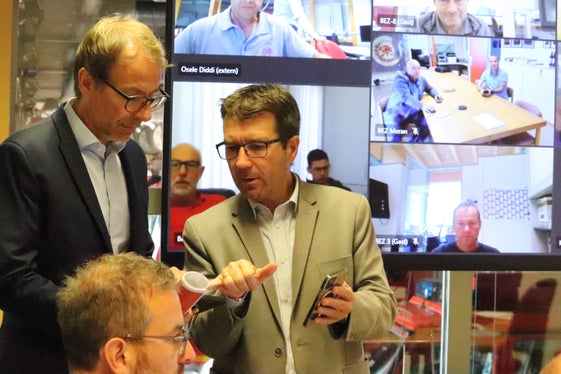 Il direttore dell'Agenzia per la Protezione civile Klaus Unterweger (a sinistra) e il direttore dell'ufficio Protezione civile, Günther Walcher (a destra) durante la fase di test: alcuni dei nove distretti dei vigili del fuoco volontari, collegati in videoconferenza, sono visibili sullo schermo alle loro spalle. (Foto: ASP/Maja Clara)