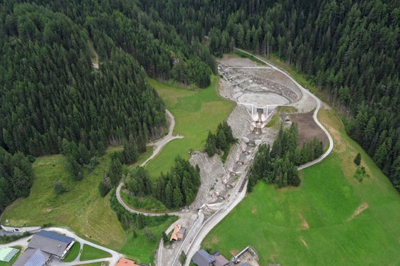 Aktuelle Aufnahme mit Blick auf das Gesamtkonzept Großbergbach mit großem Rückhaltebecken (mit Fassungsvermögen von rund 50.000 Kubikmetern) und der darunterliegenden Kammsperre, die als zweite Sicherheit Material, das bei größeren Rechen durchkommt, heraussiebt, es folgen im Bachlauf Konsolidierungssperren und ein 360 Meter langer Abschnitt mit Künette, von der man den Anfang sieht. (Foto: LPA/Agentur für Bevölkerungsschutz)