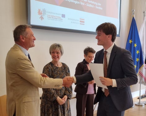 Cerimonia di consegna del diploma allo studente Sam Strotz (a destra): da sinistra il direttore Richard Seeber (Tirolo) e le direttrici Katharina Lonardi (Trentino) e Vesna Caminades (Alto Adige) dell'Ufficio di rappresentanza a Bruxelles. (Foto: Euregio)