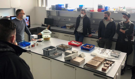Apprendisti muratori nel laboratorio di prove igrotermiche dell'Eurac con il ricercatore senior Marco Larcher (Foto: ASP/Lvh-Apa)