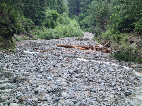 Das Geschiebematerial im Weißenbach konnte von der großen Rückhaltesperre aufgefangen werden, diese wird nun mit einer Sofortmaßnahme geräumt, um den Hochwasserschutz wieder zu gewährleisten. (Foto: LPA/Landesamt für Wildbach- und Lawinenverbauung Nord in der Agentur für Bevölkerungsschutz)