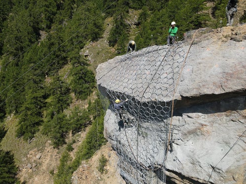 Addetti della ditta Geobau impegnati nella messa in opera delle reti di contenimento in preparazione al brillamento del costone di roccia Kastnknott sopra Colsano. (Foto: ASP/Gnews)