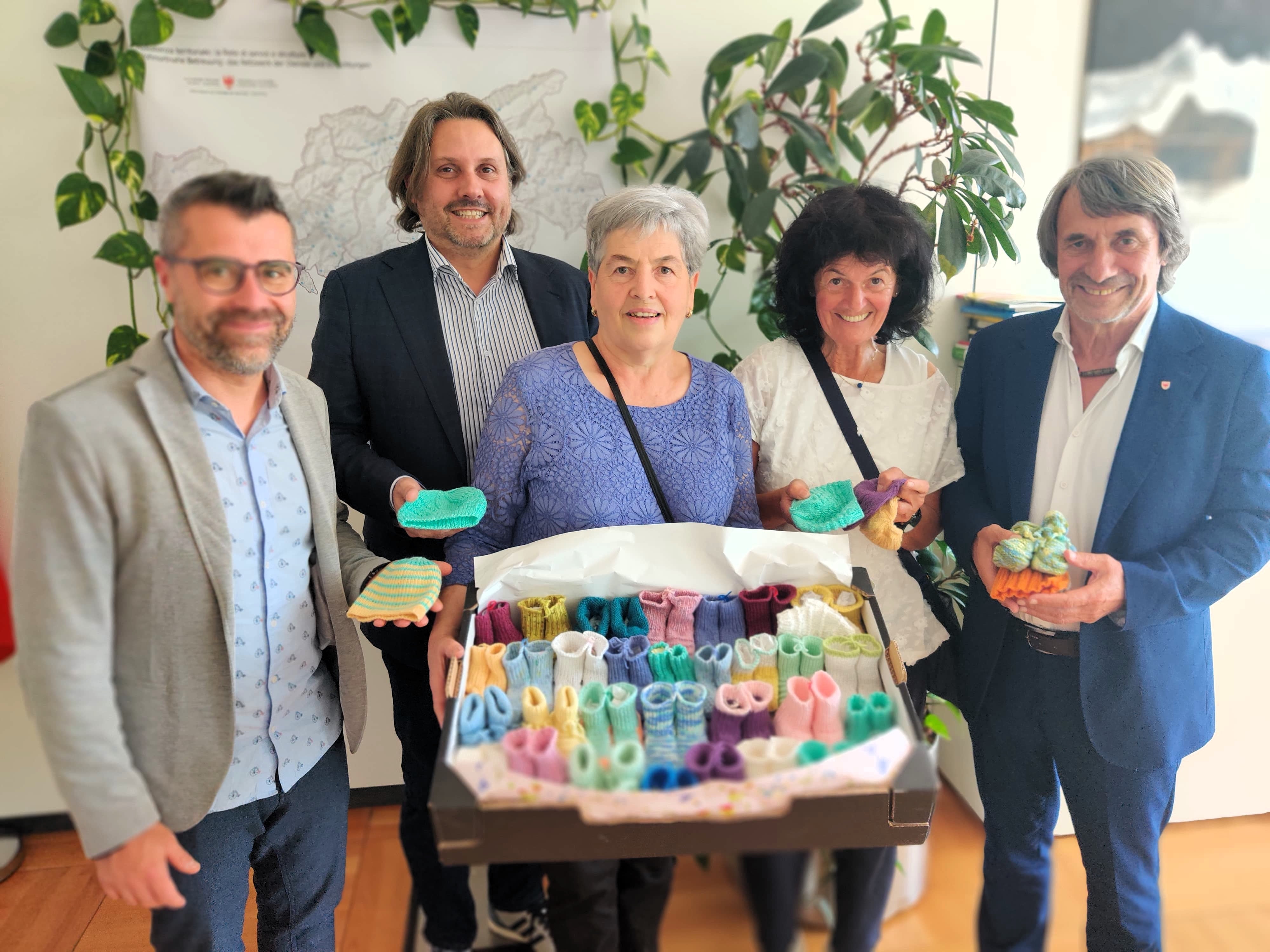 Winzig klein und mit viel Liebe gestrickt: Gesundheitslandesrat Hubert Messner (1.v.r.), Pflegekoordinator Daniele Gianotti (1.v.l.), Primar Alex Staffler (2.v.l.) erhielten in der Neonatologie Bozen handgefertigte Frühchenkleider als Zeichen der Wertschätzung für die Kleinsten – und das engagierte Team von Regina Marth (v.l.nr.) und Irene Borek. (Foto: LPA/ Gesundheitsressort)