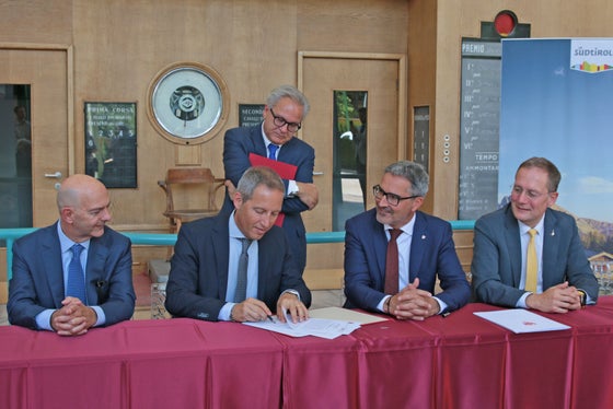 Bei der Unterzeichnung des Dokument für die Finanzierung der Arbeiten zur Aufwertung am Meraner Pferderennplatzes Meran im Kraftraum der Ehrentribüne am Meraner Pferderennplatzes. (Foto: Gemeinde Meran/Stefano Bolognesi)