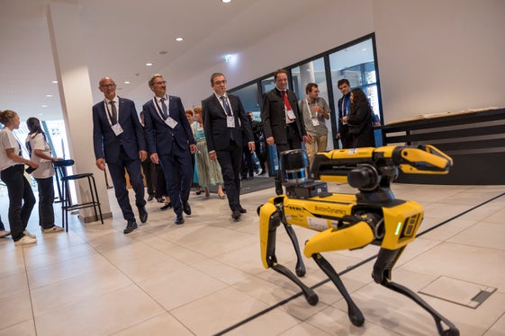 L robot avisà dala AI fej da scorta, da man ciancia, a LH Anton Mattle, al presidënt dla Euregio y presidënt dla Provinzia de Bulsan Arno Kompatscher, a LH Maurizio Fugatti y al minister austriach Norbert Totschnig de viers dl’Euregio Summit tl Zënter di Cungresc. (Foto: Land Tirol/Sedlak)   