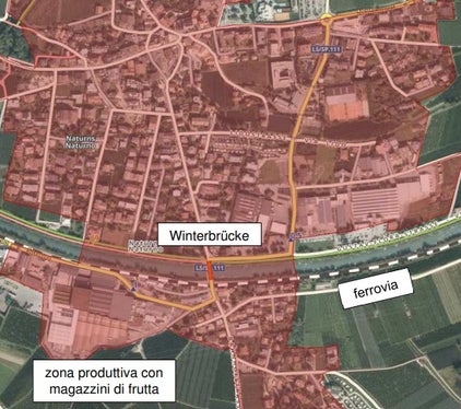 Il Winterbrücke (in rosso) lungo la SP111 (in giallo), con la linea ferroviaria della Venosta e zona per insediamenti produttivi 
con i magazzini delle cooperative dei frutticoltori (Foto: Ripartizione Infrastrutture)