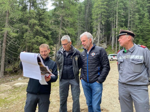 L'ingegnere progettista e direttore dei lavori dell'Ispettorato forestale di Vipiteno, Stefan Feichter, mostra al direttore Günther Unterthiner, all'assessore provinciale Arnold Schuler e all'ispettore distrettuale dei vigili del fuoco di Bressanone, Konrad Unterthiner, i piani dei lavoro. (Foto: ASP/Noemi Prinoth)