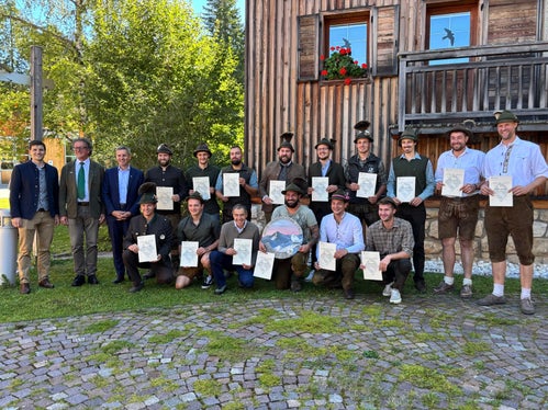 Gruppenbild der Absolventen des 11. Jagdaufseherlehrgangs mit Diplomen und Schützenscheibe und (von links) dem Direktor des Landesamtes für Wildtiermanagement Dominik Trenkwalder, Landesjägermeister Günther Rabensteiner, Forstwirtschaftslandesrat Luis Walcher (Foto: LPA)
