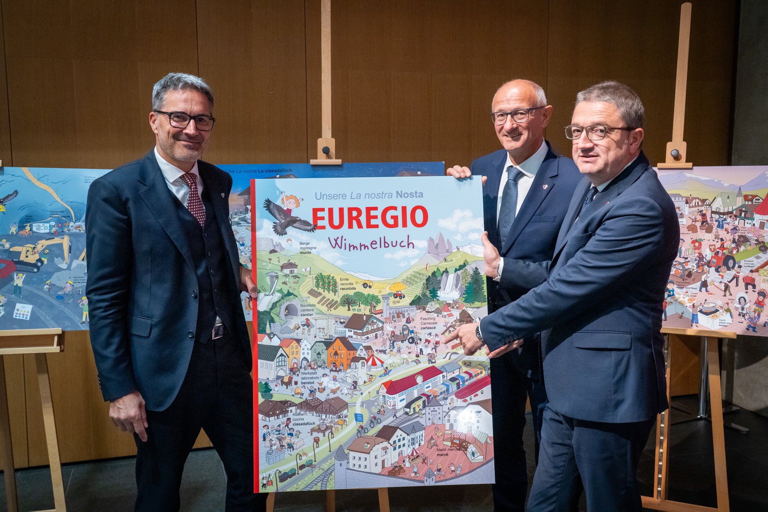 I presidenti di Alto Adige, Tirolo e Trentino con i pannelli illustrativi del libro “brulicante”: (da sinistra) Arno Kompatscher, Anton Mattle (presidente dell’Euregio) e Maurizio Fugatti (Foto: Land Tirolo/Neuner)