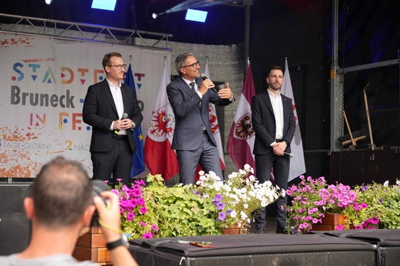 Dialogo politico sull'Euregio sul palco della festa a Brunico con (da sinistra) i rappresentanti della Giunta dell'Euregio Philip Wohlgemuth (Tirolo), il presidente dell'Euregio Arno Kompatscher (Alto Adige) e Simone Marchiori (Trentino). (Foto: Euregio/Guido Steinegger)
