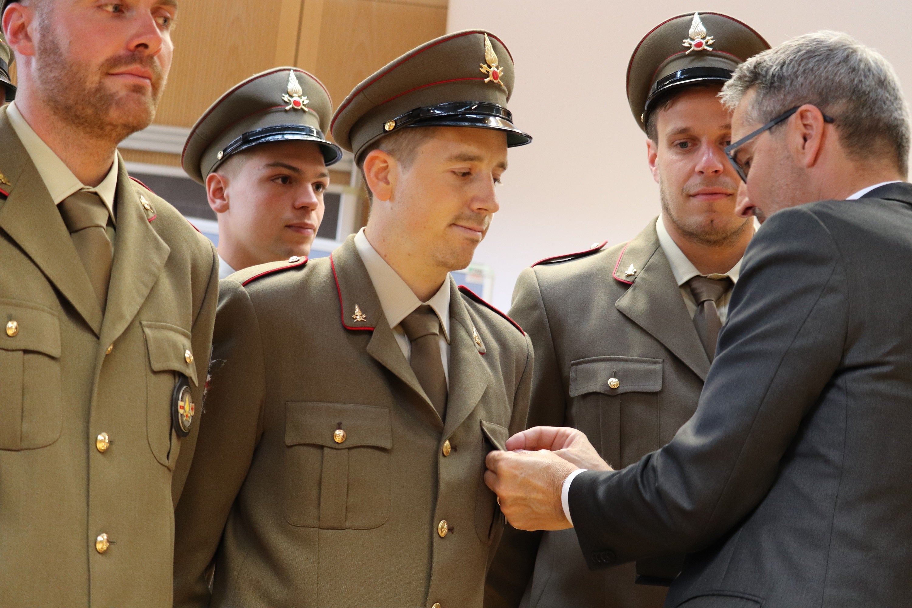 Landeshauptmann und Bevölkerungsschutzlandesrat Arno Kompatscher hat den neuen Feuerwehrleuten das Brustabzeichen angesteckt, das Teil ihrer Ausgehuniform ist und ihre Zugehörigkeit zur Berufsfeuerwehr signalisiert. (Foto: LPA/Maja Clara)